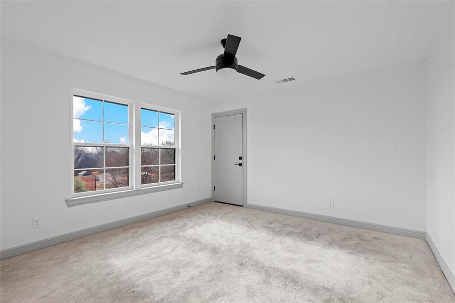 Carpeted spare room featuring ceiling fan