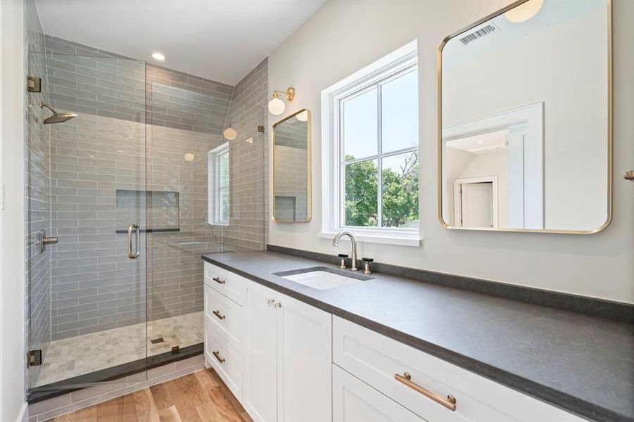 Bathroom with vanity, walk in shower, and hardwood / wood-style floors