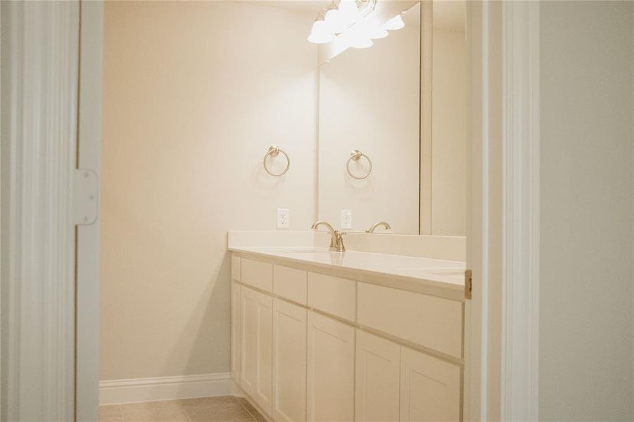 Bathroom featuring tile patterned flooring, vanity, and a chandelier