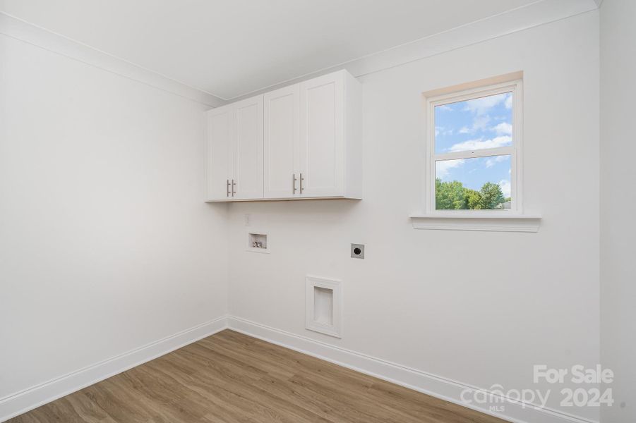 Representative Photo. Laundry room comes with built-in cabinets, recessed exhaust vent, window & option for sink