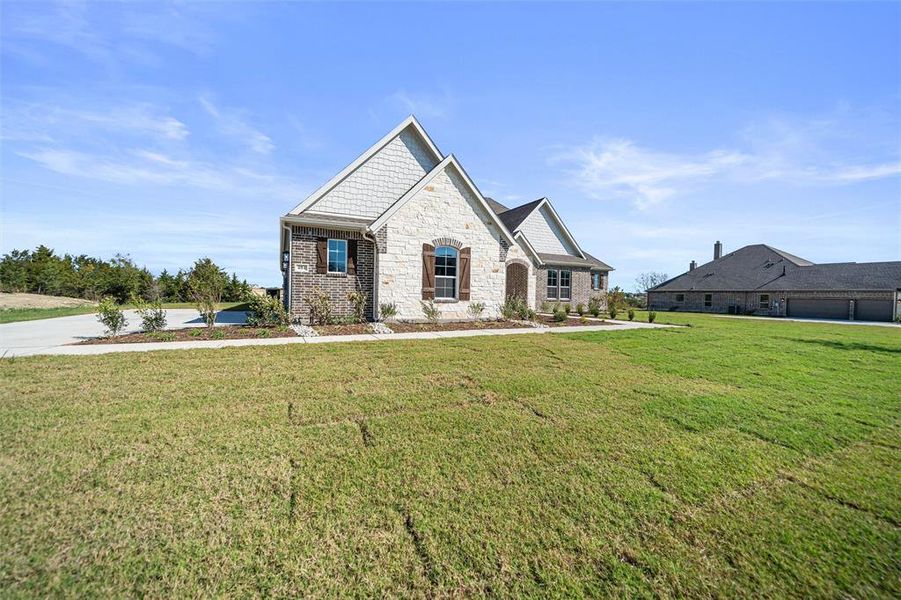 View of front facade with a front lawn and stone siding View of front facade with a front lawn and stone siding