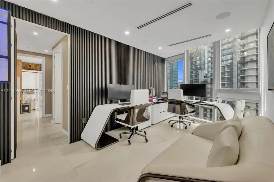 Floor-to-ceiling windows, dark wood-slat accent wall, recessed lighting, and large-format tile flooring Floor-to-ceiling windows, dark wood-slat accent wall, recessed lighting, and large-format tile flooring
