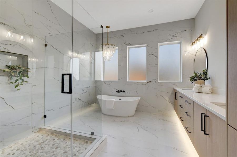 Spacious Master Bathroom featuring separate shower and tub, vanity, and an inviting chandelier