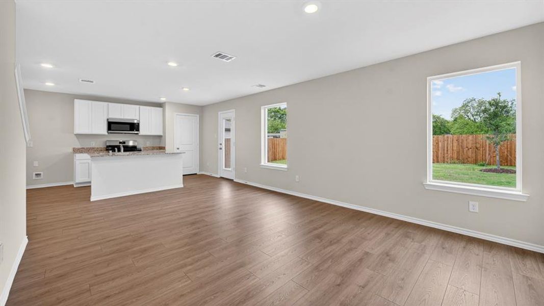Open-concept living area featuring wood-finish flooring, recessed lighting, and light gray walls