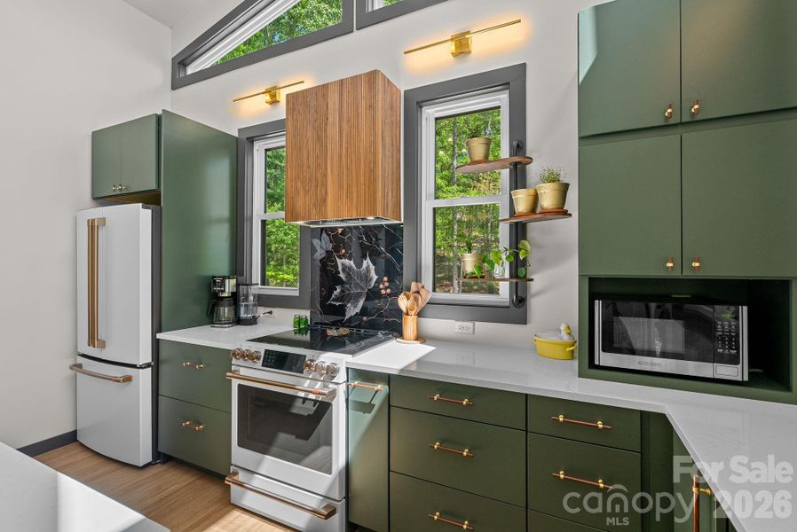 Deep moss green cabinets set the stage for wood + brass accents & quartz counters + GE Cafe series appliances.