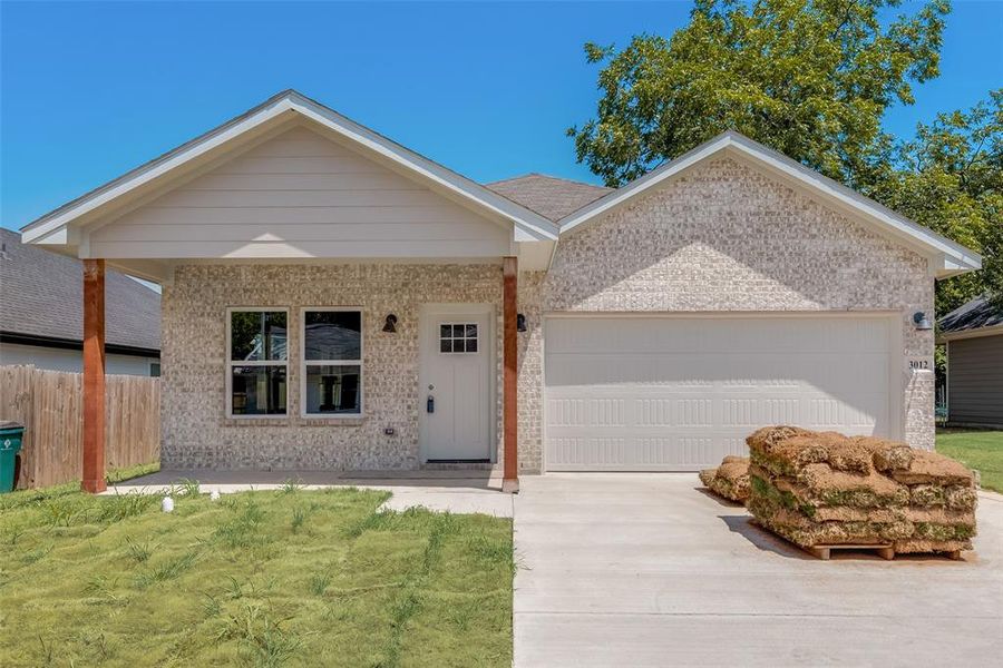 Ranch-style home featuring a front yard and a garage