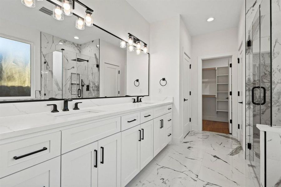 Bathroom with double vanity, a marble finish shower, light marble finish floors, a walk in closet, and recessed lighting