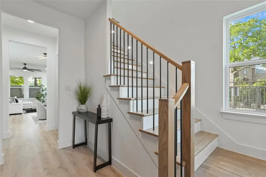 Stairs featuring wood finished floors and ceiling fan