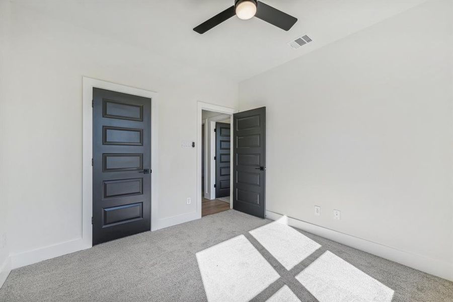 Unfurnished bedroom with ceiling fan and light carpet