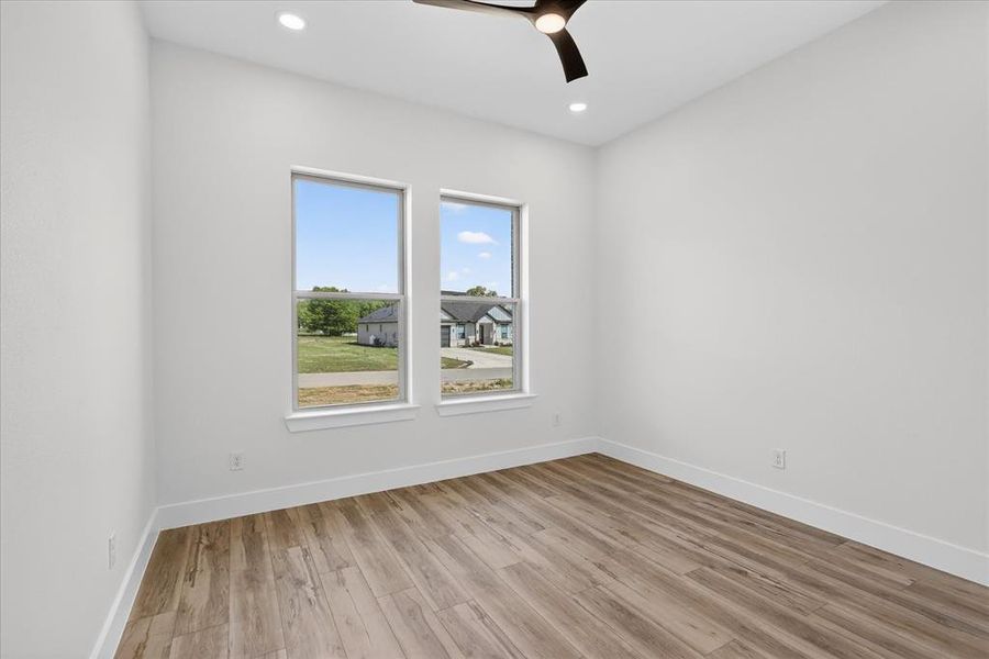 Unfurnished room featuring light wood-type flooring, a ceiling fan, and recessed lighting