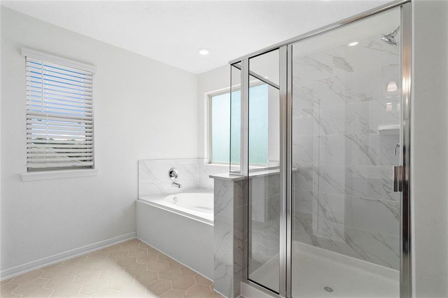 This primary bathroom is definitely move-in ready! Featuring a walk-in shower with tile surround, separate garden tub for soaking after a long day with custom tile detailing, custom paint, sleek and large windows to bring in the natural light.