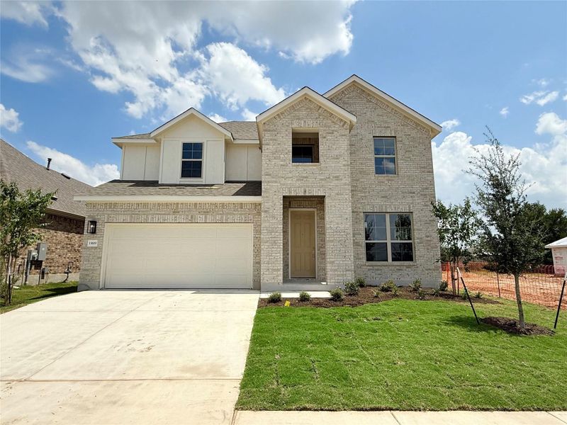 View of front of home with concrete driveway, an attached garage, a front yard, brick siding, and roof with shingles View of front of home with concrete driveway, an attached garage, a front yard, brick siding, and roof with shingles