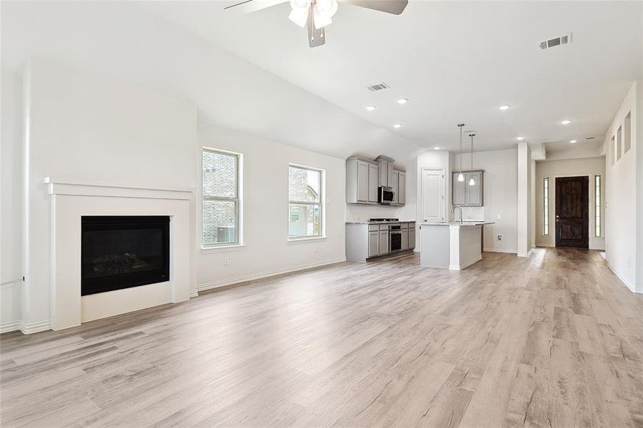 Unfurnished living room with ceiling fan and light wood-type flooring