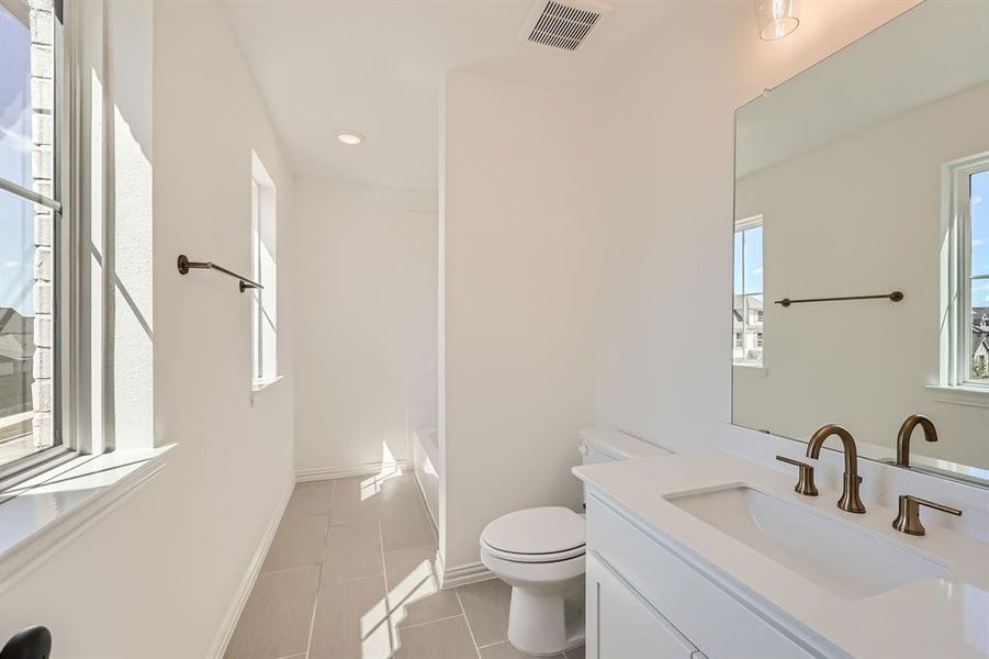 Bathroom with tile patterned flooring, vanity, and toilet