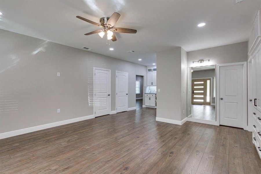 Unfurnished living room with dark wood-style floors, recessed lighting, a ceiling fan, and healthy amount of natural light