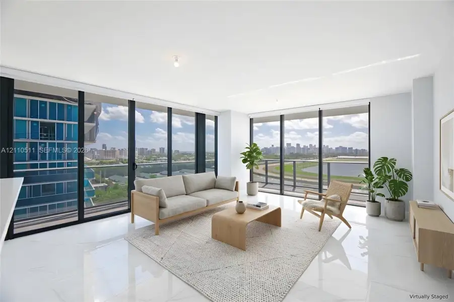 Floor-to-ceiling windows featuring panoramic city and track scenery, complemented by polished tile flooring and recessed ceiling lighting