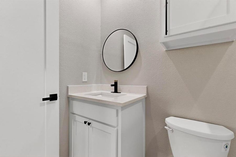 Half bath with a textured wall and vanity Half bath with a textured wall and vanity