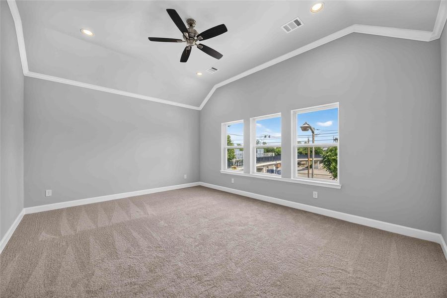 Primary Bedroom Retreat – Vaulted ceilings, plush carpeting, and natural light combine to create a peaceful and spacious haven.
