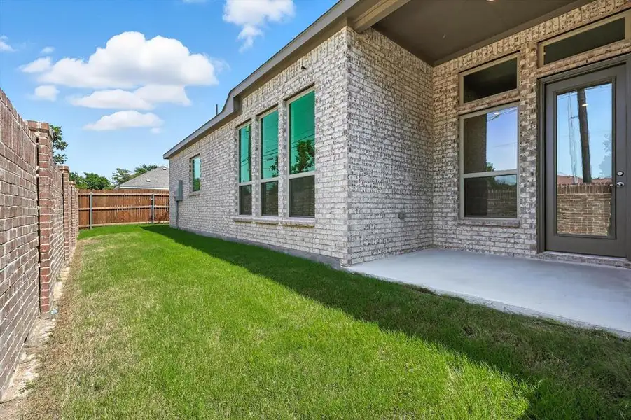View of home's exterior with a fenced backyard, brick siding, and a patio View of home's exterior with a fenced backyard, brick siding, and a patio