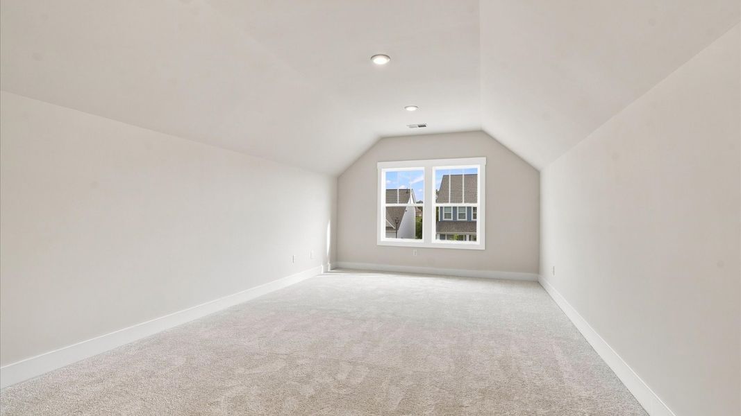 Inviting bonus room with cozy carpet, perfect for casual gatherings or quiet relaxation at Wells Crossing