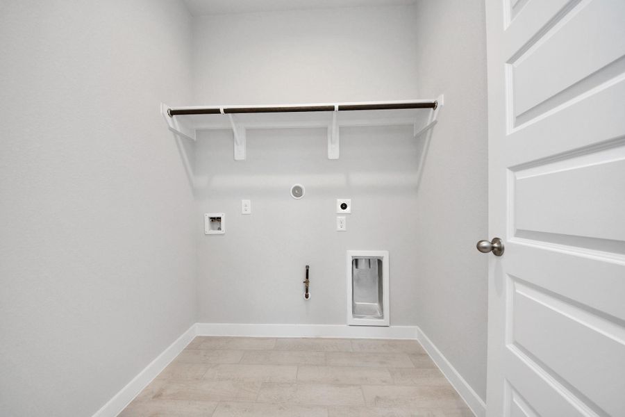 A perfect blend of functionality and comfort. Capture the essence of easy living with a first-floor laundry room, thoughtfully equipped with shelving for effortless organization. Both electric and gas connections available. Sample photo of completed home with similar floor plan. Actual colors and selections may vary. A perfect blend of functionality and comfort. Capture the essence of easy living with a first-floor laundry room, thoughtfully equipped with shelving for effortless organization. Both electric and gas connections available. Sample photo of completed home with similar floor plan. Actual colors and selections may vary.