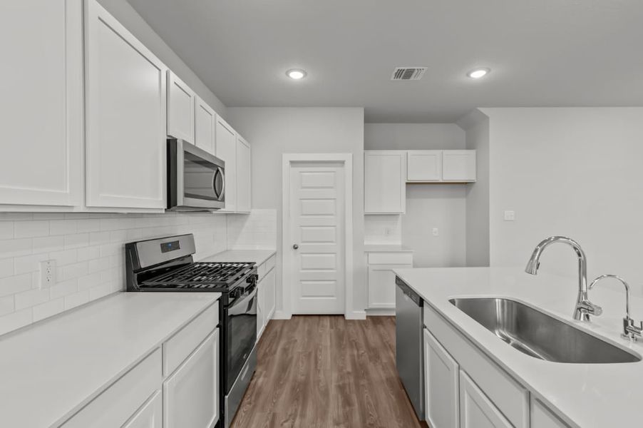 A kitchen with white cabinets.