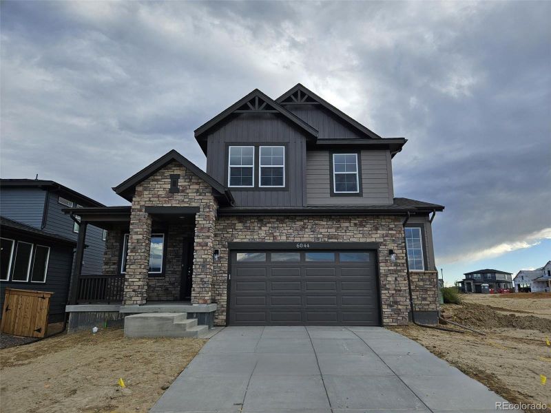 Front exterior of a new home in The Cottages Collection at Ridgeline Vista, Brighton, CO, highlighting curb appeal (Image 1). Front exterior of a new home in The Cottages Collection at Ridgeline Vista, Brighton, CO, highlighting curb appeal (Image 1).