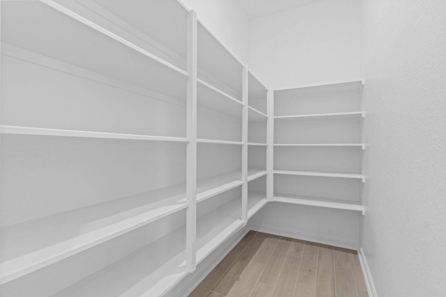 Expansive walk-in pantry with abundant shelving, providing excellent storage and organization for kitchen essentials.