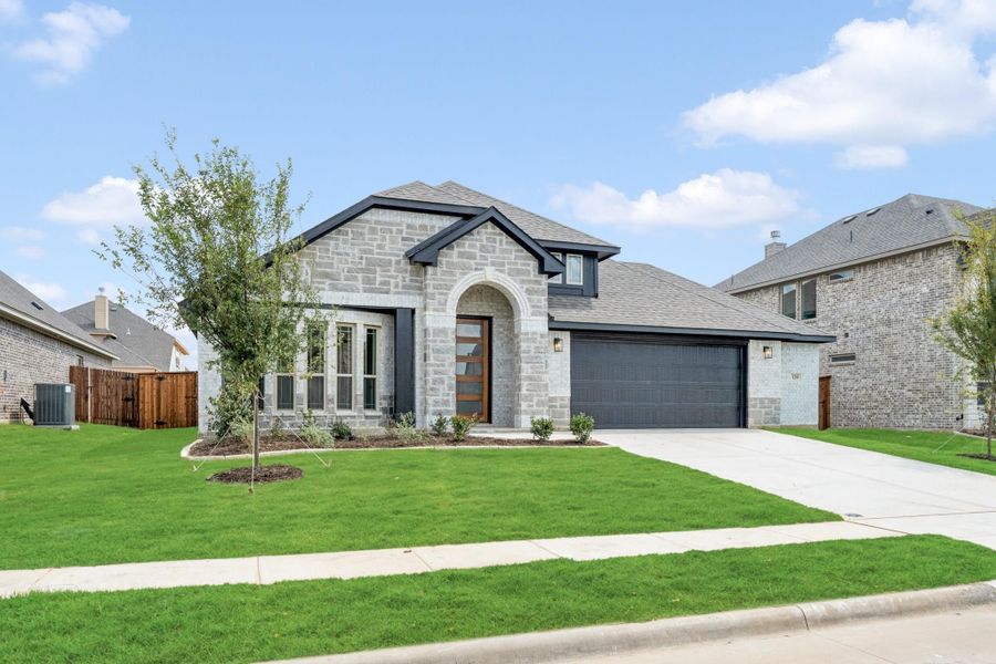 Single-story home with stone exterior, arched entry, two-car garage, and green front lawn
