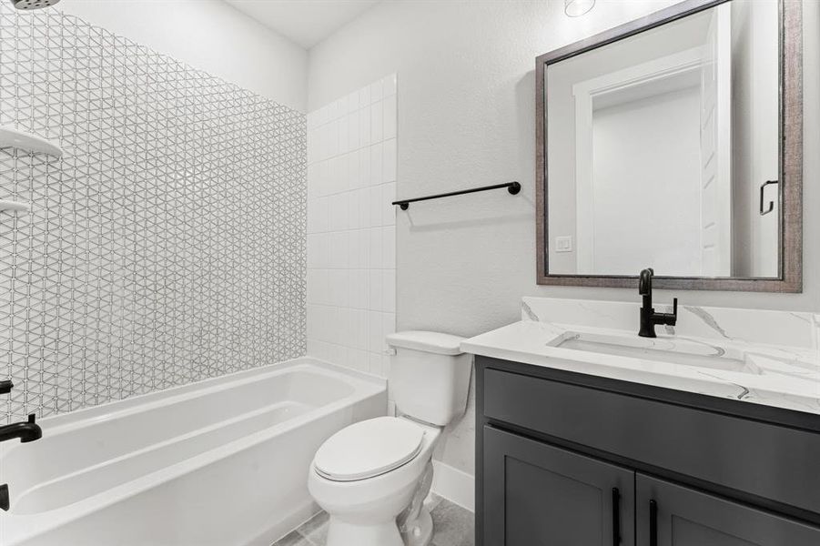 Full bathroom with vanity, toilet, and tiled shower / bath combo