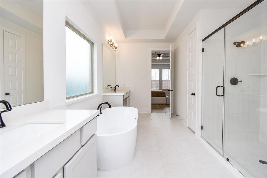 The ensuite primary bathroom is designed to evoke a spa-like experience, featuring a separate soaking tub perfect for relaxation and a large walk-in shower that offers a luxurious retreat.