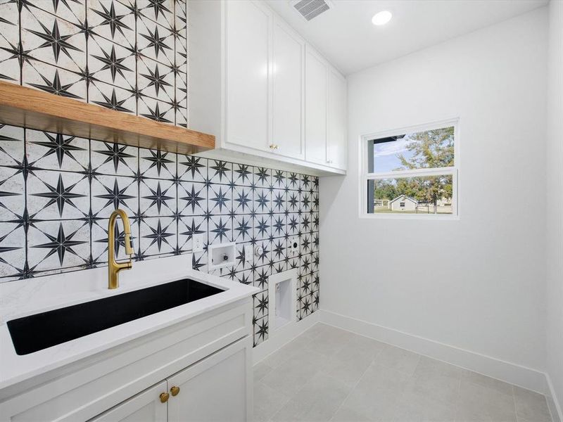 Washroom featuring cabinet space and hookup for a washing machine