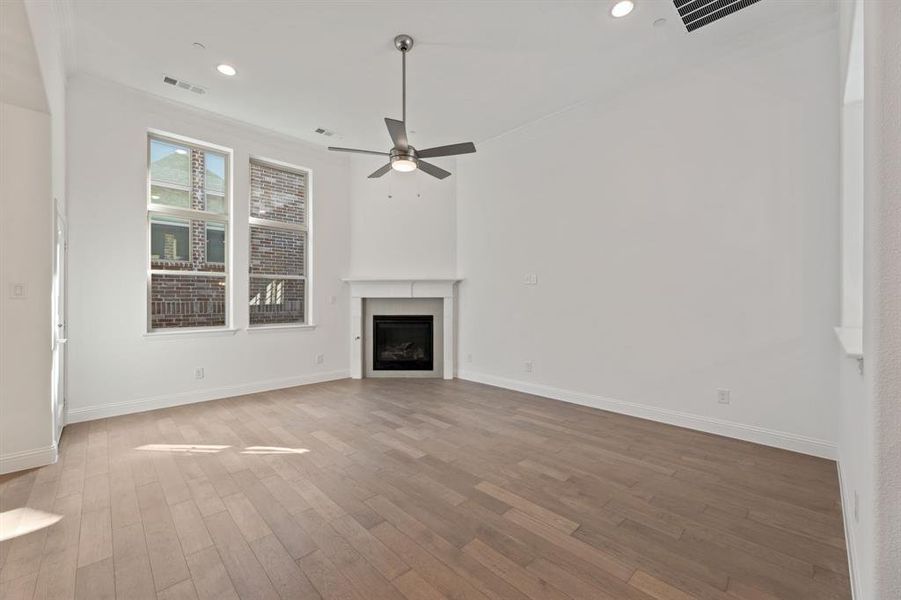 Unfurnished living room with ceiling fan and hardwood / wood-style floors