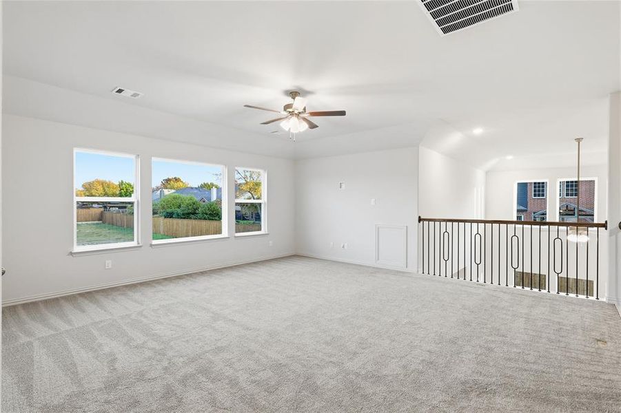 Empty room with a ceiling fan and carpet floors