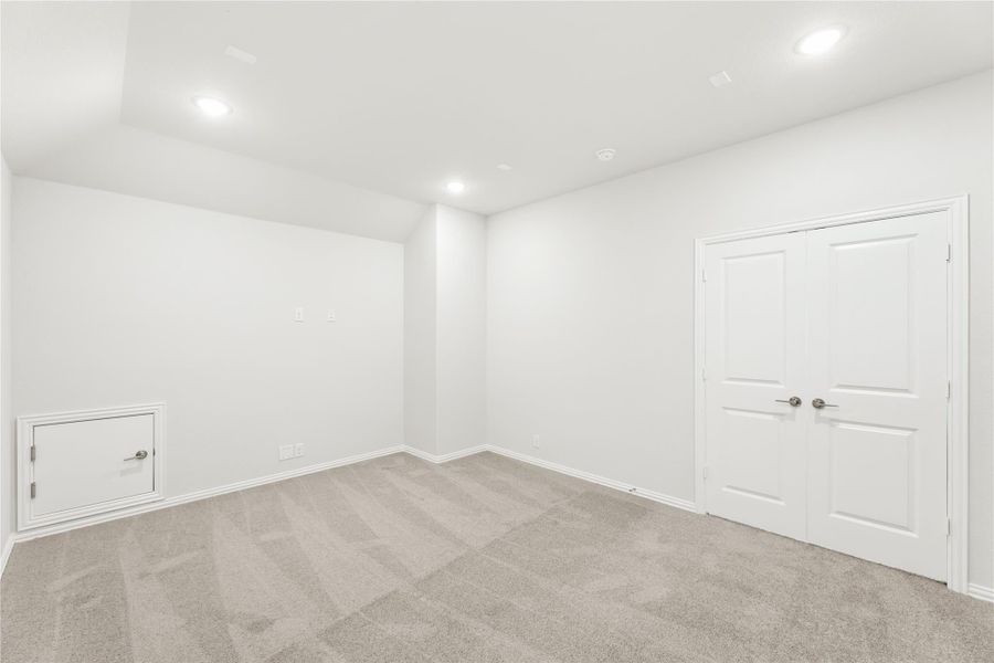 Empty room with white walls, carpet flooring, double doors, and a small wall access panel Empty room with white walls, carpet flooring, double doors, and a small wall access panel