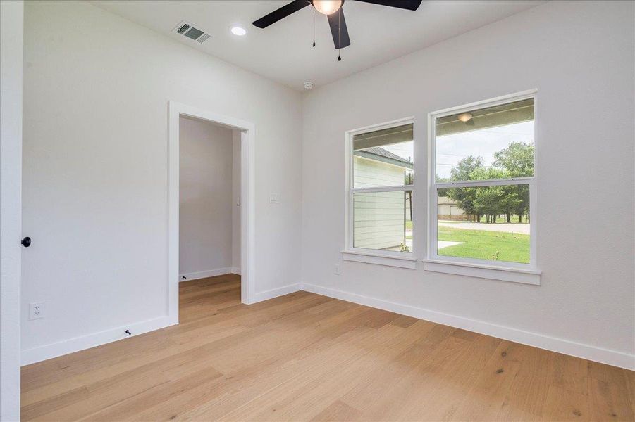 Blonde wood flooring and large windows create an airy, bright office space.