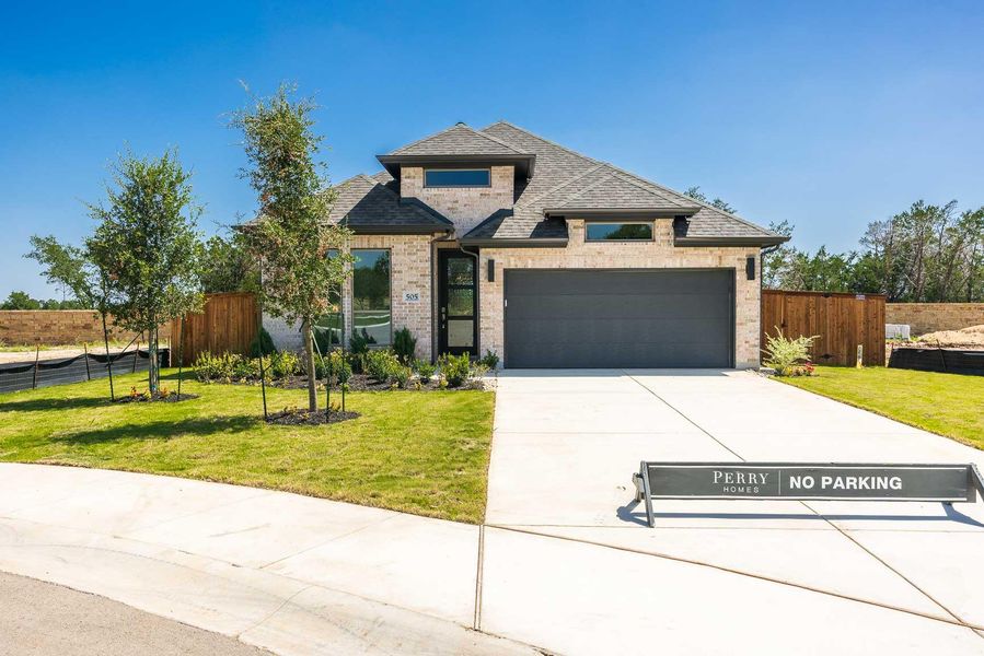 French country home with roof with shingles, driveway, brick siding, and a garage French country home with roof with shingles, driveway, brick siding, and a garage