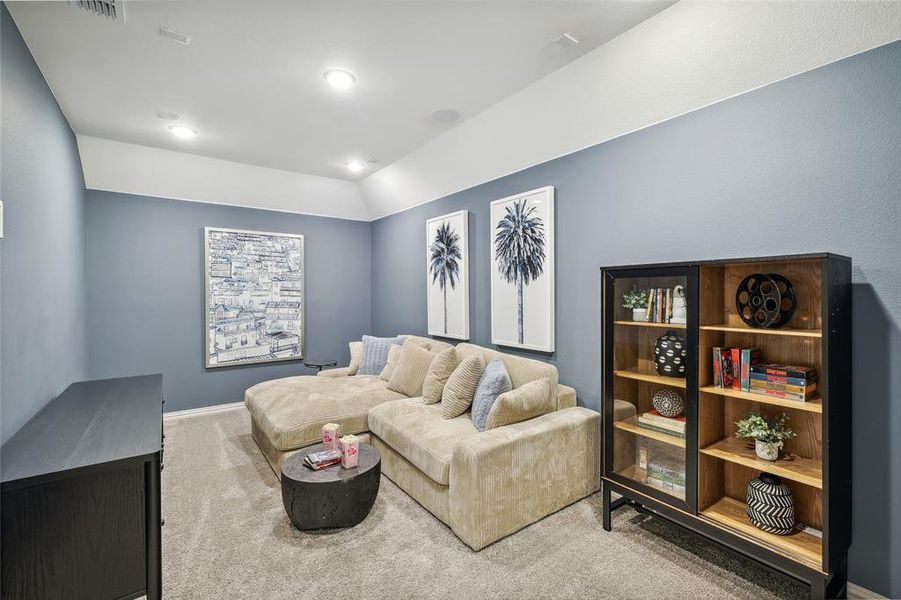 Carpeted living room featuring lofted ceiling