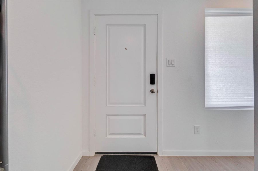 Bright and welcoming front entry with modern finishes and convenient keyless entry.