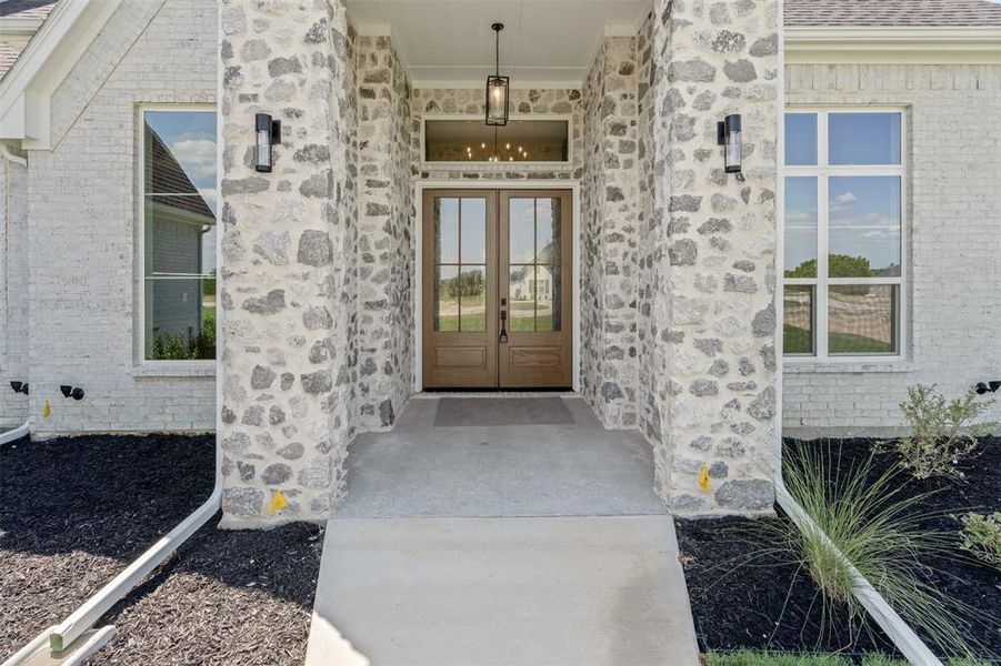 Property entrance with stone siding, french doors, and brick siding Property entrance with stone siding, french doors, and brick siding