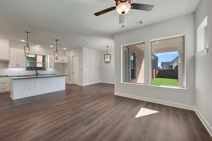 Unfurnished living room featuring dark wood-style floors and ceiling fan