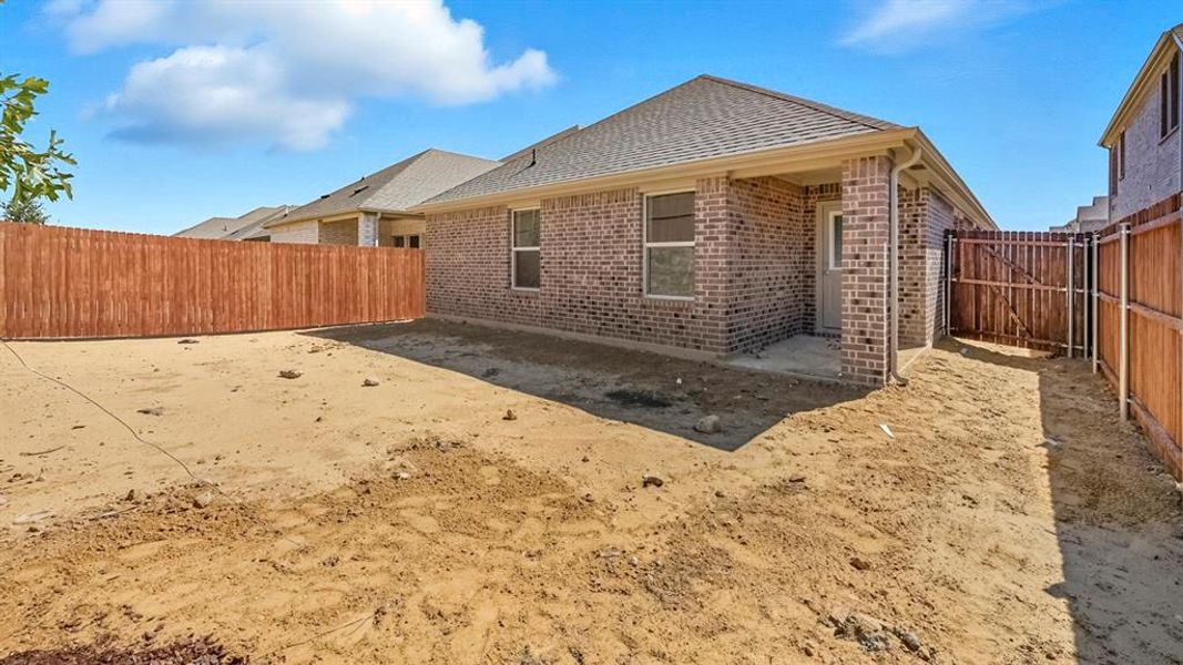 Rear view of house featuring a patio area, a fenced backyard, roof with shingles, and brick siding Rear view of house featuring a patio area, a fenced backyard, roof with shingles, and brick siding