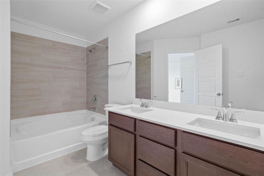 This stunning primary bathroom is truly move-in ready! It features stained cabinetry with light countertops, dual sinks, a large mirror, high ceilings, custom paint, and sleek modern finishes throughout. This stunning primary bathroom is truly move-in ready! It features stained cabinetry with light countertops, dual sinks, a large mirror, high ceilings, custom paint, and sleek modern finishes throughout.