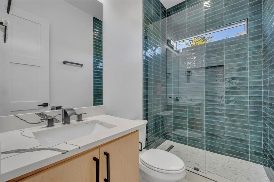 Bathroom with vanity, an enclosed shower, and toilet