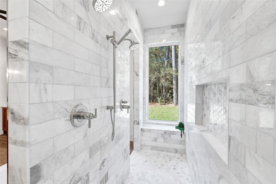This property features a beautifully crafted bathroom with custom tile work, complemented by a luxurious dual-head shower for an enhanced showering experience.