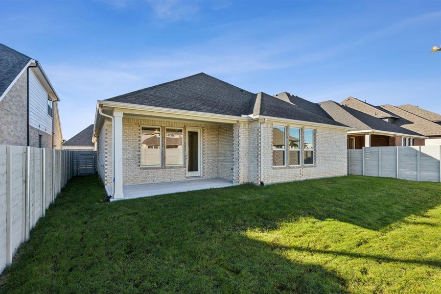 Back of house with a patio area and a yard