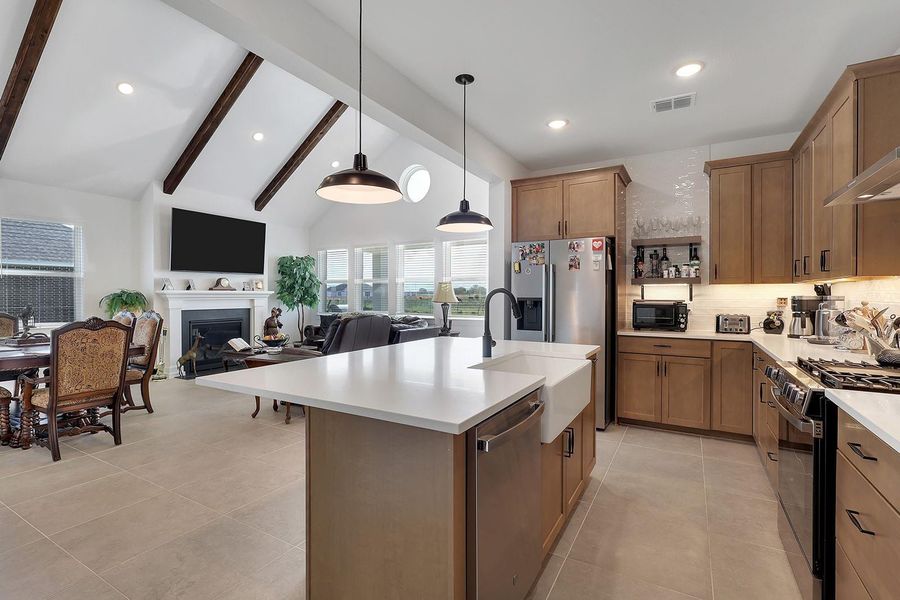 This photo shows it all with a farmhouse modern open-concept kitchen and living area. The exposed living/dining room beam tie it all in together. Warm and inviting for gatherings.