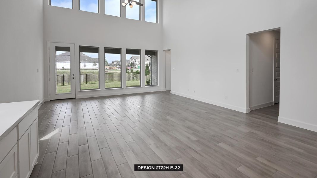 Unfurnished living room with wood finished floors and a towering ceiling