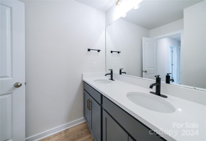 Secondary Bathroom Up features upgraded cabinets, quartz countertops, upgraded faucets and lighting