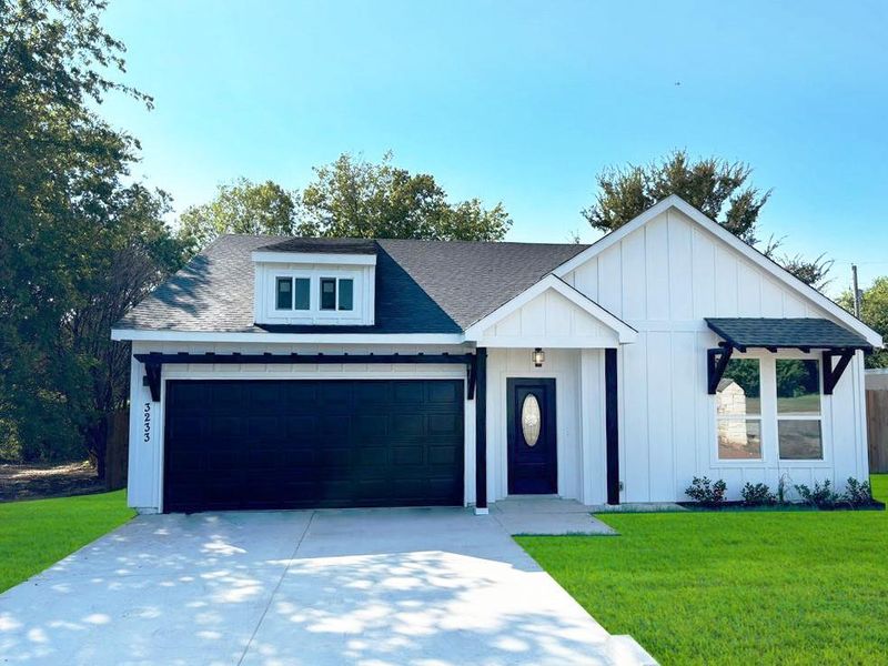 Modern farmhouse style home with a garage and a front lawn